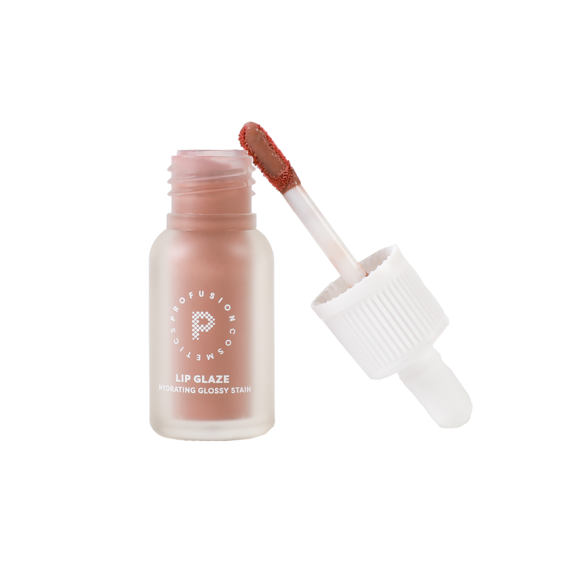 Profusion Cosmetics Vanilla Lip Glaze bottle with applicator propped up next to it.