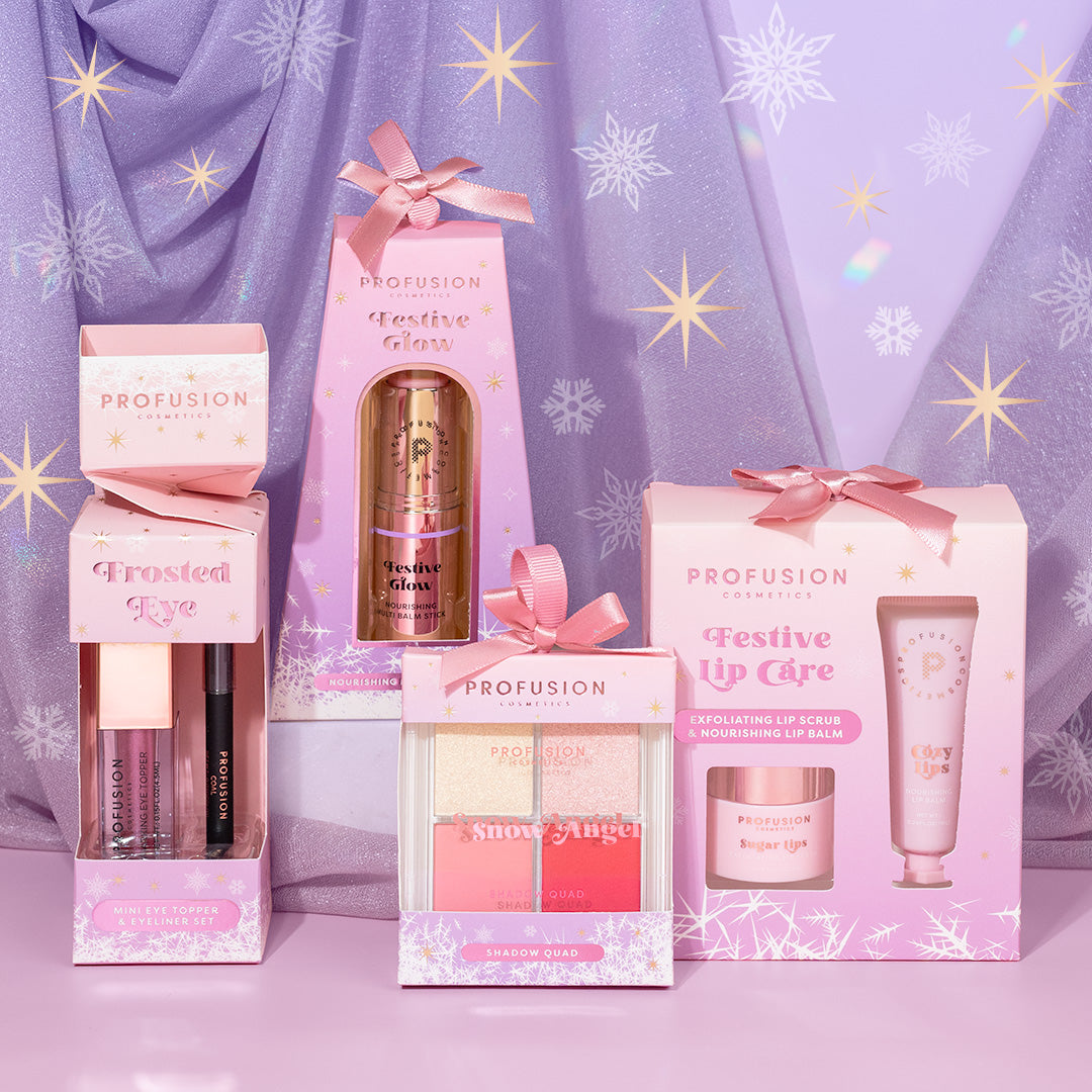 a lifestyle image with group of snow frosted sparkle collection with pink color boxed packaging and pink ribbon