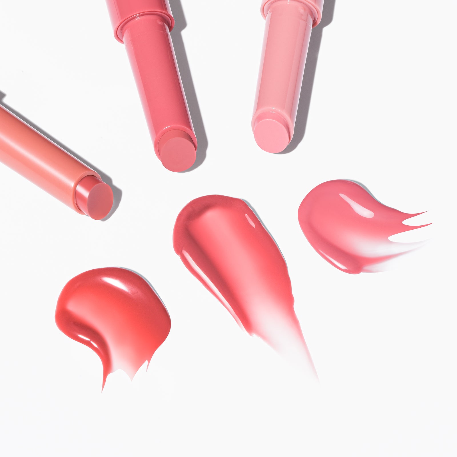 Lipsticks in shades of pink and coral from Profusion Cosmetics, with swatches showcasing vibrant colors.