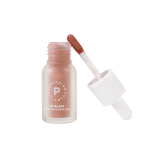 Profusion Cosmetics Vanilla Lip Glaze bottle with applicator propped up next to it.