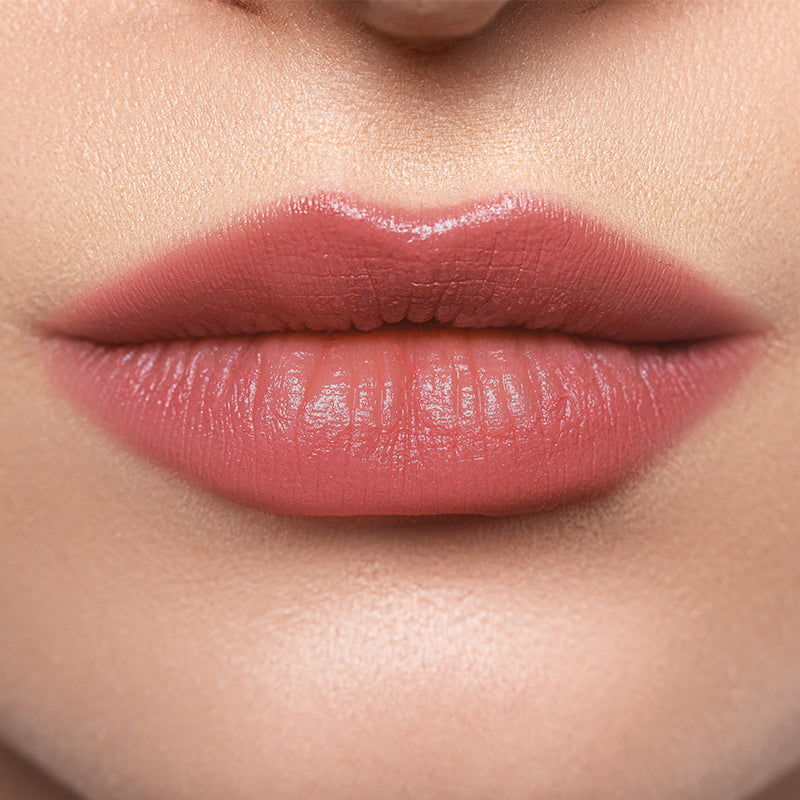 Close-up of lips wearing Profusion Lychee Glaze, showing a soft rosy tint with a subtle glossy finish.