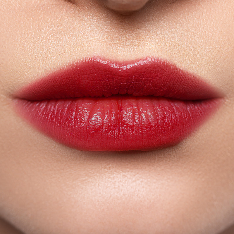 Close-up of lips wearing Profusion Raspberry Glaze, showing a rich berry-red tint with a soft glossy finish.