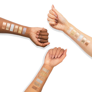 Arm swatches of Profusion Cosmetics' Moonstone glittery eyeshadow in gold, silver, and bronze.