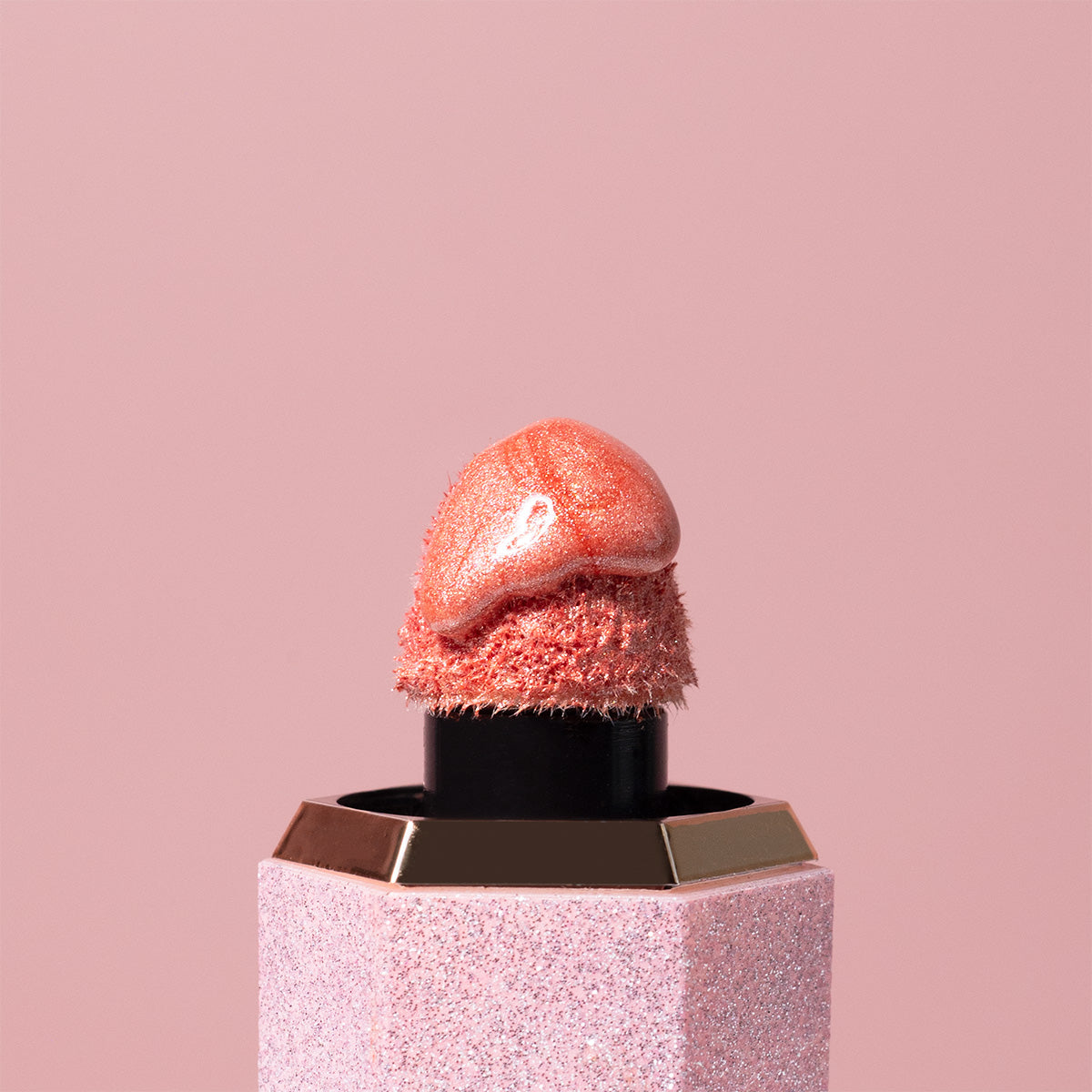 A shimmery pink lipstick from Profusion Cosmetics, featuring a glittery texture and a soft, glossy finish.