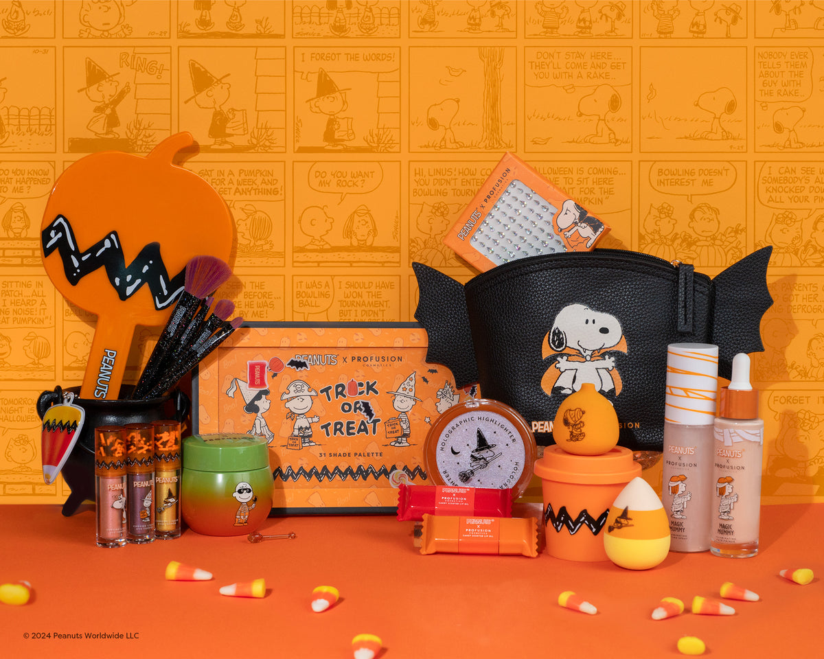 Profusion Cosmetics' Peanuts collection featuring vibrant orange and black themed makeup products, including eyeshadow palettes, brushes, and lip oils, makeup bags, and more adorned with Snoopy and Halloween motifs.